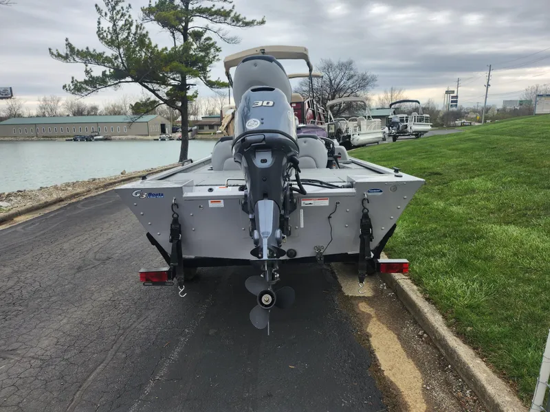 Slide: The Image of 2016 G3 Eagle 166 boat with outboard motor on a trailer by a lakeside road. - 2