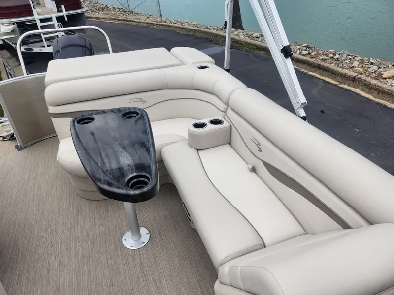Slide: The Image of 2017 Bennington 20 SLMX pontoon boat interior with beige seating and black table. - 11