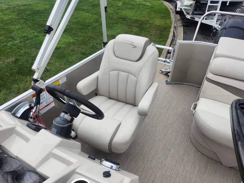Slide: The Image of 2017 Bennington 20 SLMX boat interior with beige captain's chair and steering wheel. - 12