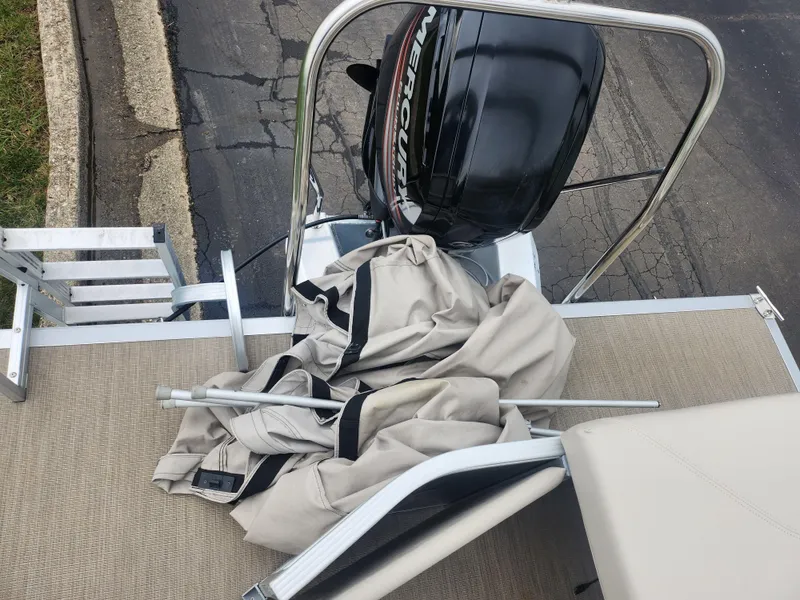 Slide: The Image of 2017 Bennington 20 SLMX boat with Mercury outboard motor and folded canopy on deck. - 16