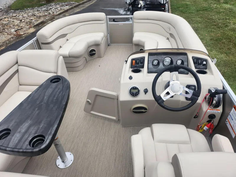 Slide: The Image of 2017 Bennington 20 SLMX pontoon boat interior with beige seating and steering console. - 18