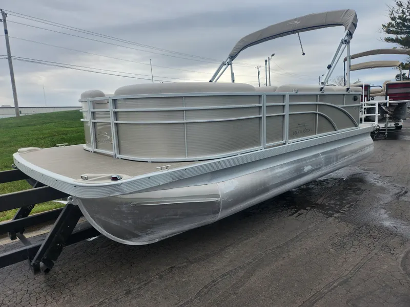 Slide: The Image of 2017 Bennington 20 SLMX pontoon boat on a trailer, overcast sky background. - 5