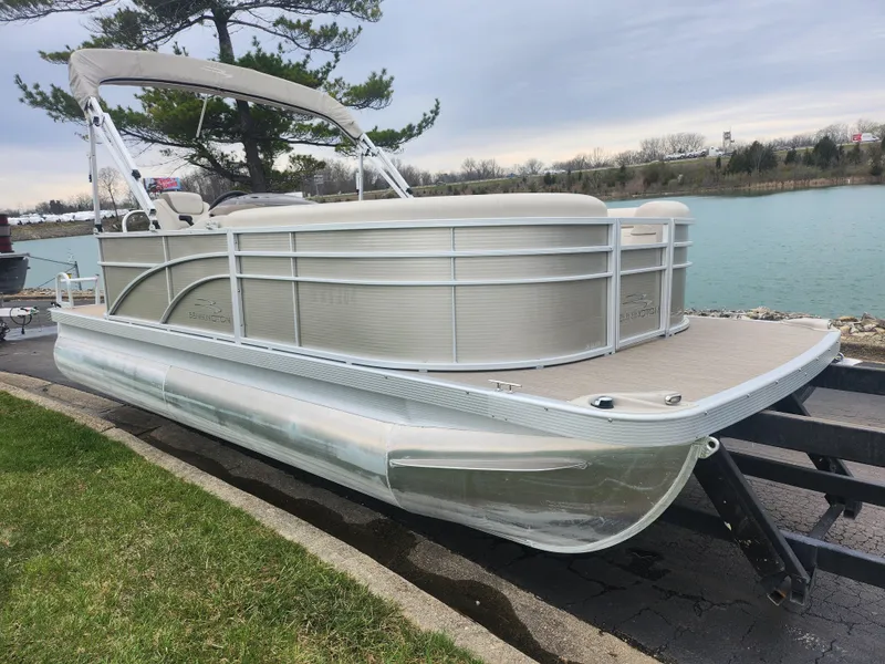 Slide: The Image of 2017 Bennington 20 SLMX pontoon boat docked by a serene lake. - 7