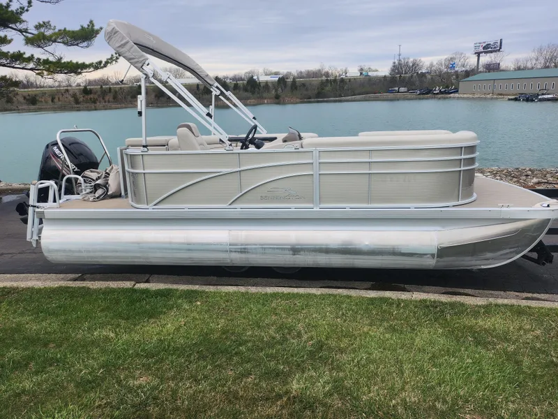 Slide: The Image of 2017 Bennington 20 SLMX pontoon boat docked by a serene lake. - 8