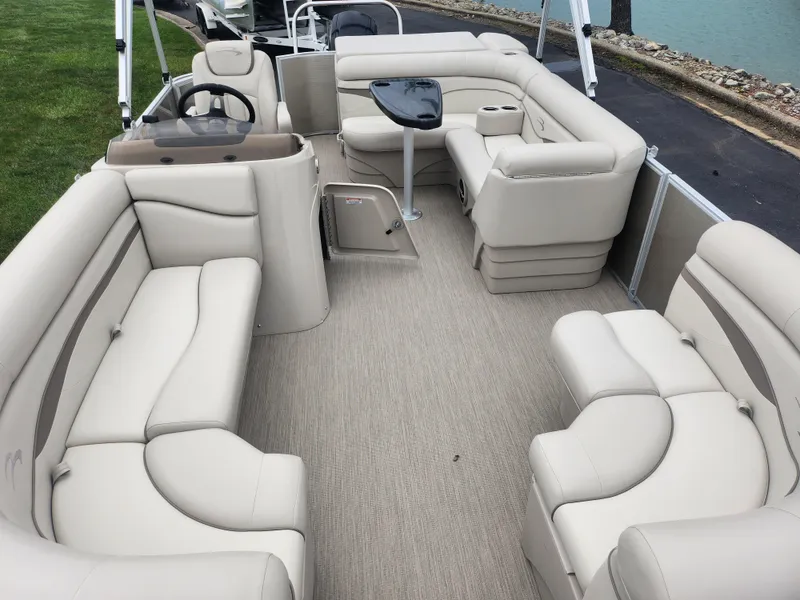 Slide: The Image of 2017 Bennington 20 SLMX pontoon boat with spacious beige seating and a central table. - 9