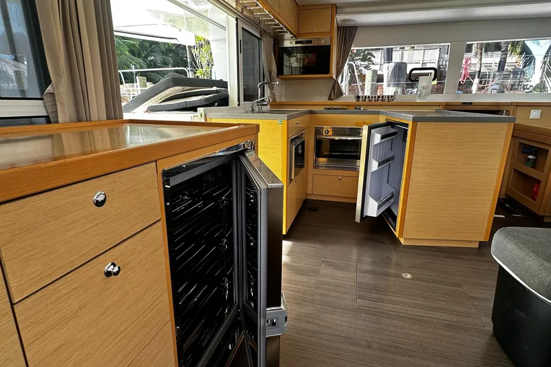 Slide: The Image of Interior of 2017 Lagoon 450 F yacht kitchen with open appliances and wooden cabinetry. - 20