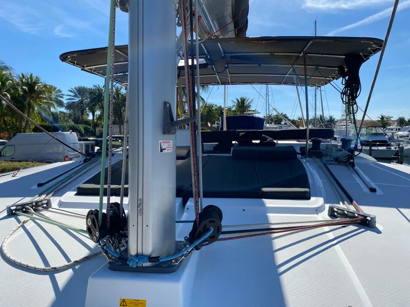 Slide: The Image of 2017 Lagoon 450 F catamaran deck with sunshade and rigging, docked in a marina. - 3