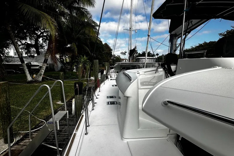Slide: The Image of 2017 Lagoon 450 F catamaran docked, surrounded by lush greenery and palm trees. - 6