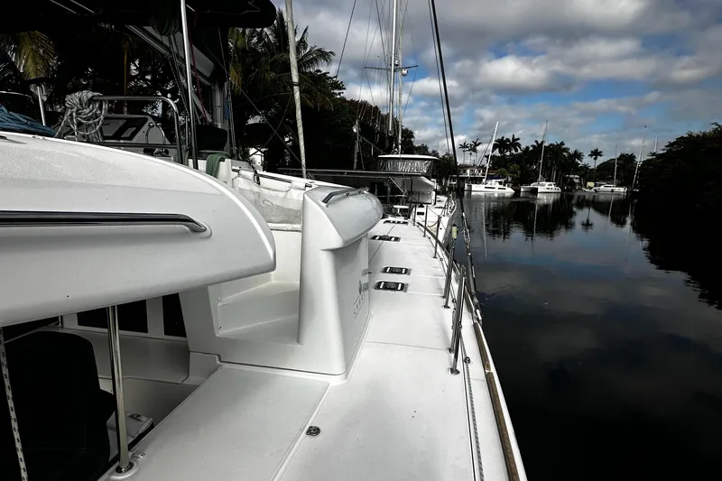 Slide: The Image of 2017 Lagoon 450 F catamaran docked by a calm, reflective waterway. - 7