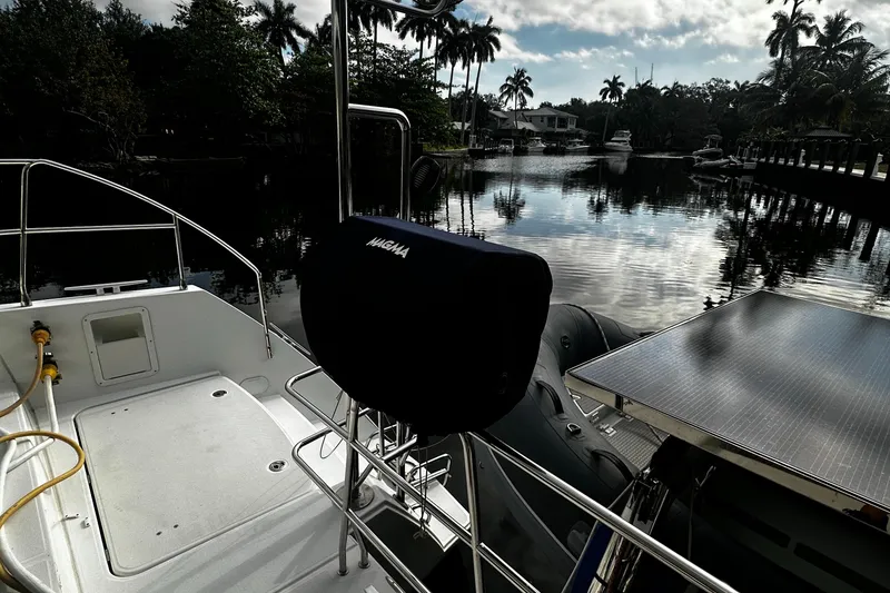 Slide: The Image of 2017 Lagoon 450 F catamaran docked by a serene, palm-lined waterway. - 70