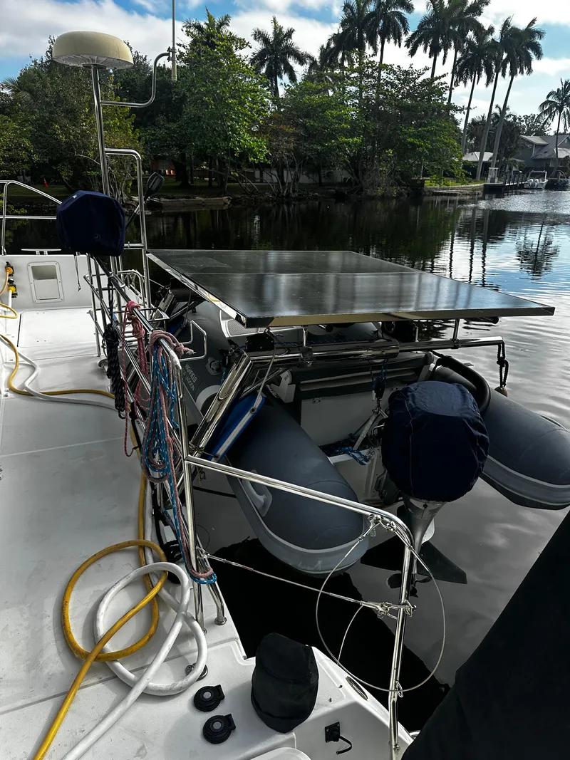Slide: The Image of 2017 Lagoon 450 F catamaran docked by a serene, palm-lined waterway. - 72