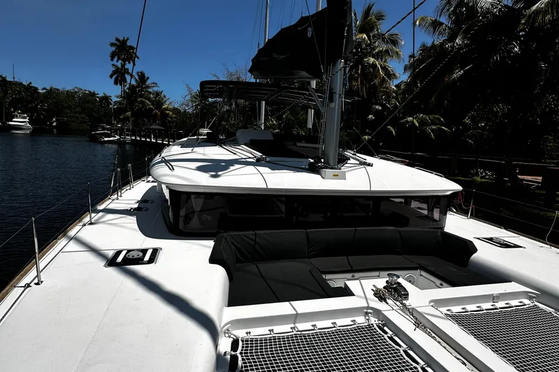 Slide: The Image of 2017 Lagoon 450 F catamaran docked by tropical trees and calm water. - 8