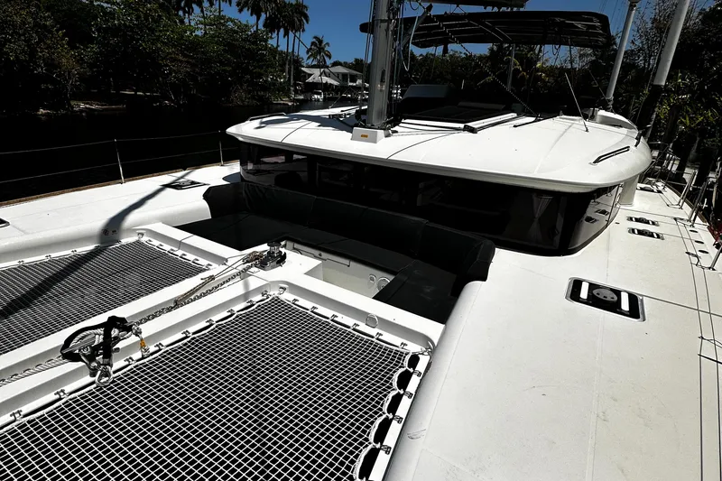 Slide: The Image of 2017 Lagoon 450 F catamaran deck with netting, docked near palm trees. - 9