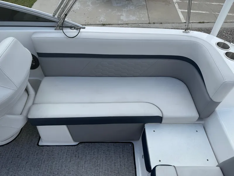 Slide: The Image of 2021 Hurricane SunDeck 217 OB boat interior with white cushioned seating and cup holders. - 19