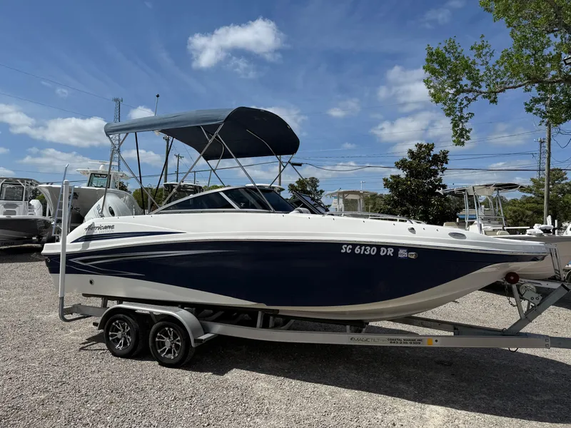 Slide: The Image of 2021 Hurricane SunDeck 217 OB boat on trailer, parked outdoors under blue sky. - 25