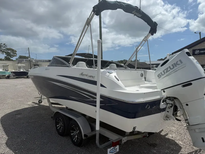 Slide: The Image of 2021 Hurricane SunDeck 217 OB boat with Suzuki outboard motor on a trailer. - 3