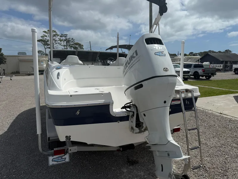 Slide: The Image of 2021 Hurricane SunDeck 217 OB boat with Suzuki outboard motor, parked on gravel lot. - 4