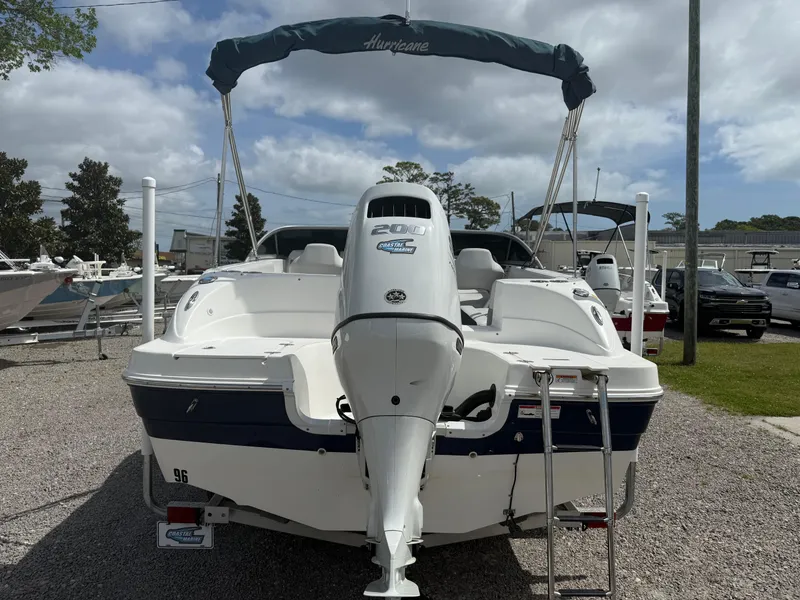 Slide: The Image of 2021 Hurricane SunDeck 217 OB boat with outboard motor, parked on gravel lot. - 5