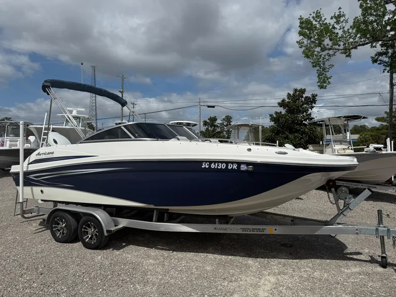 Slide: The Image of 2021 Hurricane SunDeck 217 OB boat on trailer, parked outdoors under cloudy sky. - 8