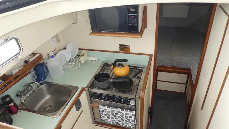 Slide: The Image of Interior of 1992 Camano 31 boat with kitchen and sleeping area. - 14