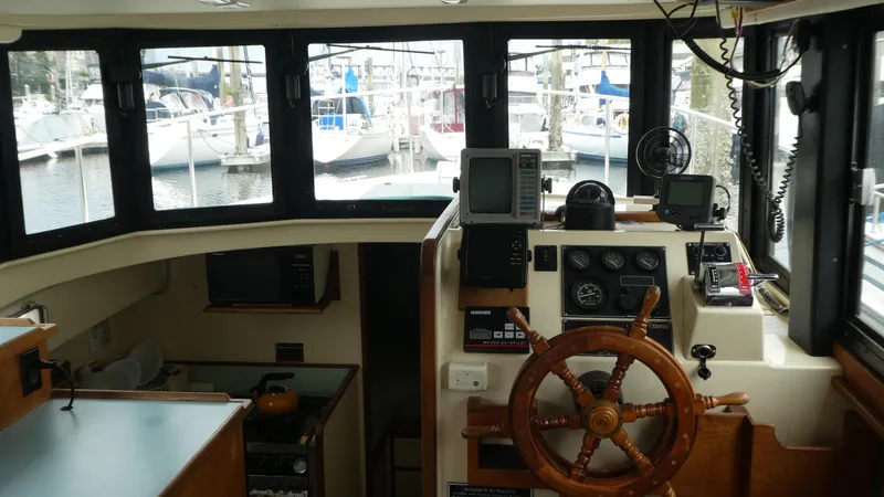 Slide: The Image of Interior view of 1992 Camano 31 boat cockpit with steering wheel and navigation equipment. - 15