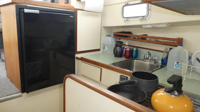Slide: The Image of Compact kitchen in a 1992 Camano 31 boat with sink, fridge, and cookware. - 16