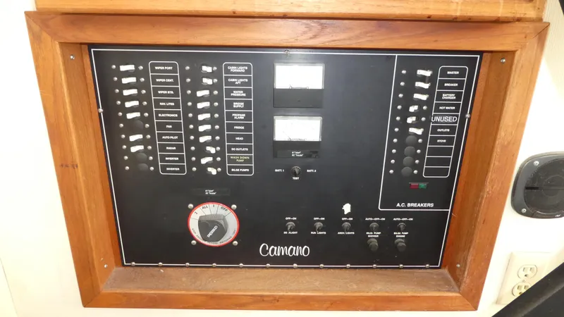 Slide: The Image of Electrical control panel of a 1992 Camano 31 boat, featuring switches and gauges. - 18