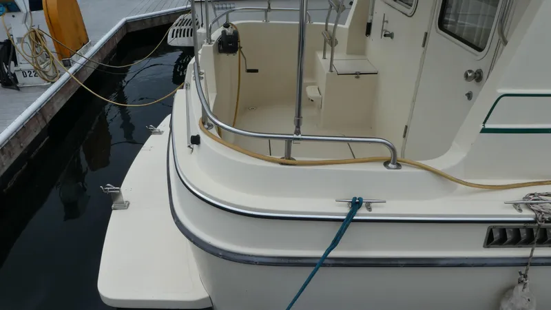 Slide: The Image of 1992 Camano 31 boat docked, showing rear deck and railing details. - 2
