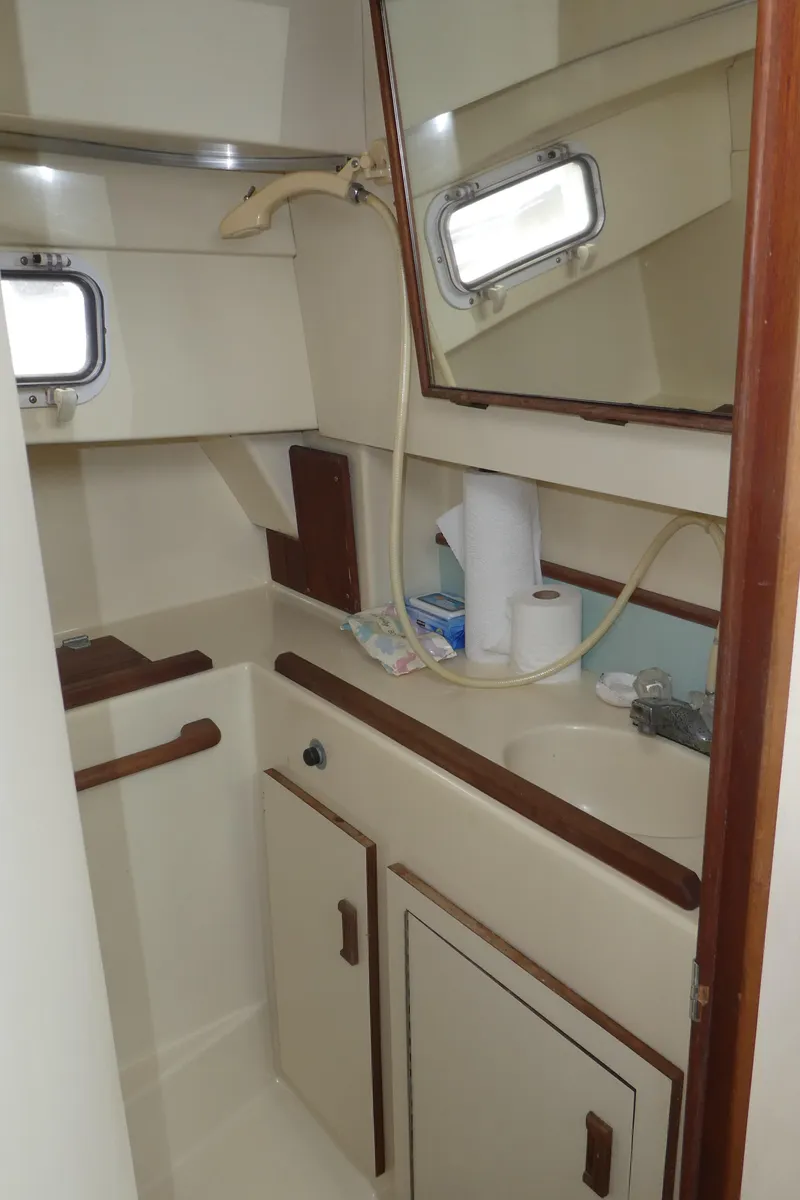 Slide: The Image of 1992 Camano 31 boat bathroom with sink, mirror, and storage cabinets. - 23