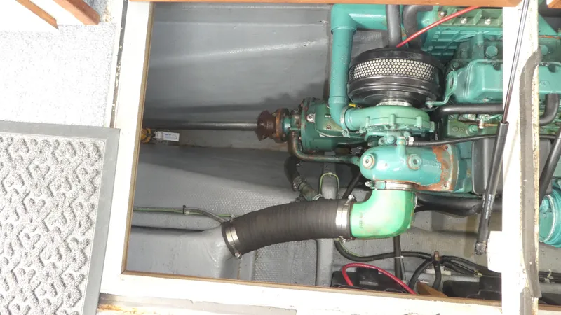 Slide: The Image of Engine compartment of a 1992 Camano 31 boat, showcasing mechanical components and piping. - 25