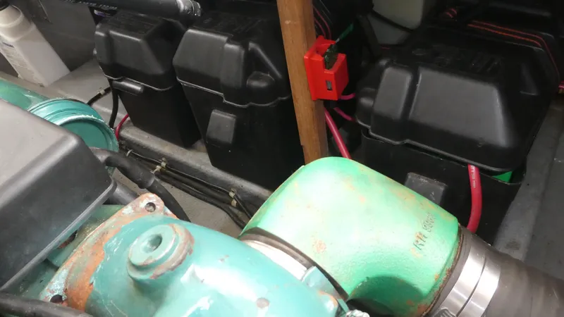 Slide: The Image of Engine compartment of a 1992 Camano 31 boat, featuring batteries and wiring. - 26