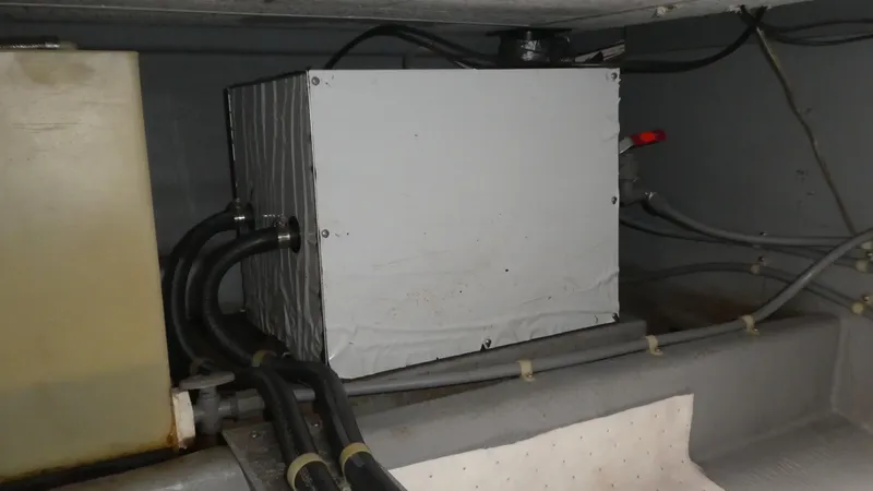 Slide: The Image of Engine compartment of a 1992 Camano 31 boat, featuring mechanical components and wiring. - 30