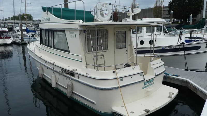 Slide: The Image of 1992 Camano 31 boat docked at marina, featuring green canopy and white hull. - 39