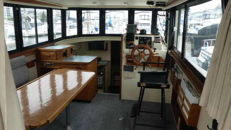 Slide: The Image of Interior of a 1992 Camano 31 boat with wooden furnishings and large windows. - 4