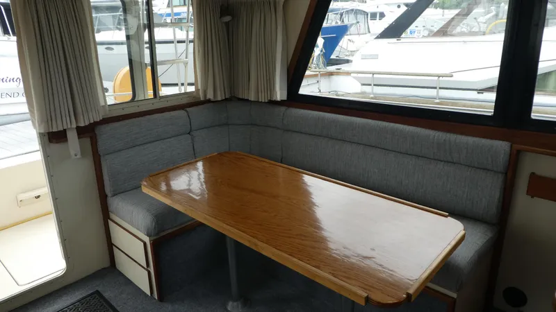 Slide: The Image of Interior of 1992 Camano 31 boat with wooden table and gray seating. - 6