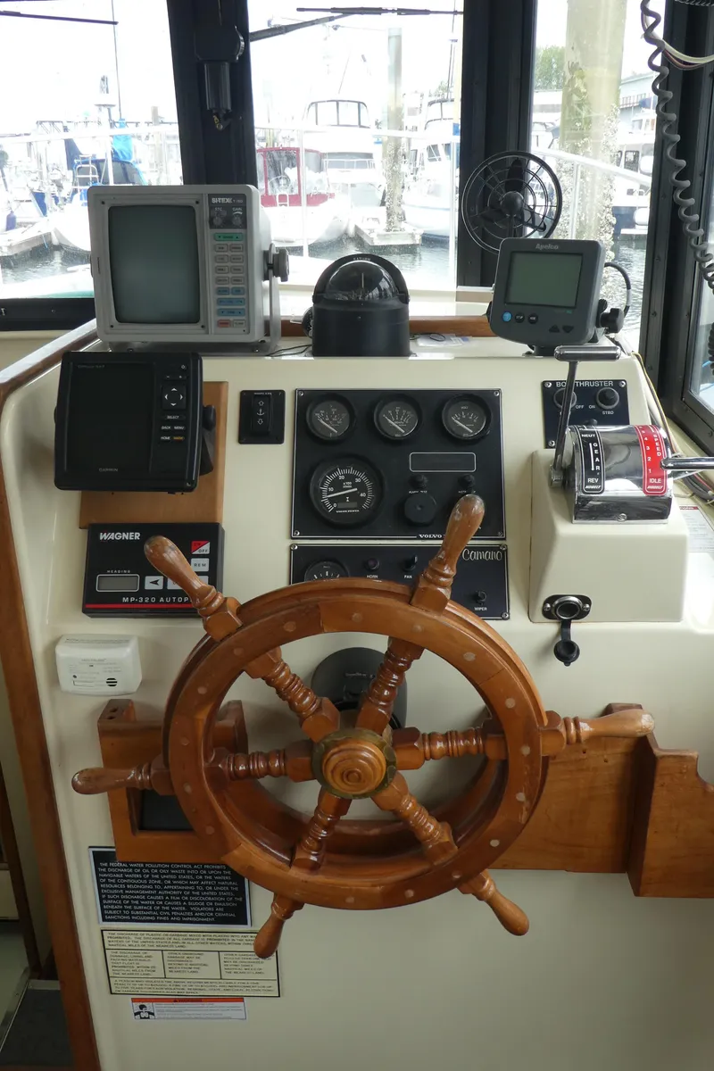 Slide: The Image of 1992 Camano 31 boat helm with wooden wheel and navigation instruments. - 9