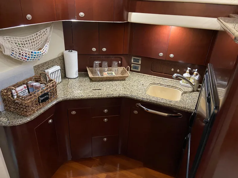 Slide: The Image of Luxurious 2006 Sea Ray 40MY yacht kitchen with granite countertops and wooden cabinetry. - 15