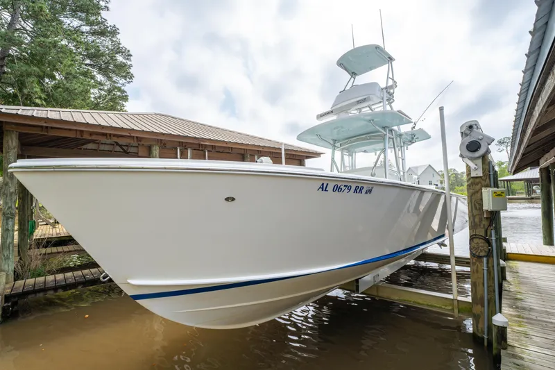 Slide: The Image of 2018 Albury Brothers 33 boat docked, showcasing sleek design and elevated helm station. - 2