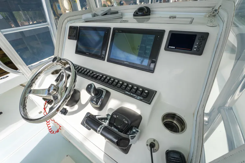 Slide: The Image of Control panel of 2018 Albury Brothers 33 boat with steering wheel and navigation screens. - 24