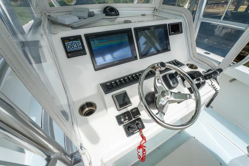 Slide: The Image of 2018 Albury Brothers 33 boat dashboard with steering wheel and navigation screens. - 25