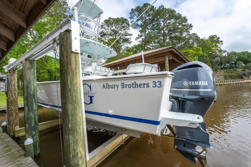 Slide: The Image of 2018 Albury Brothers 33 boat with Yamaha engine on a lift by a dock. - 3