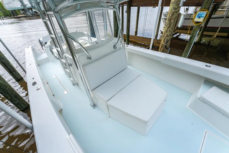 Slide: The Image of 2018 Albury Brothers 33 boat with white seating and sleek design, docked by the water. - 33
