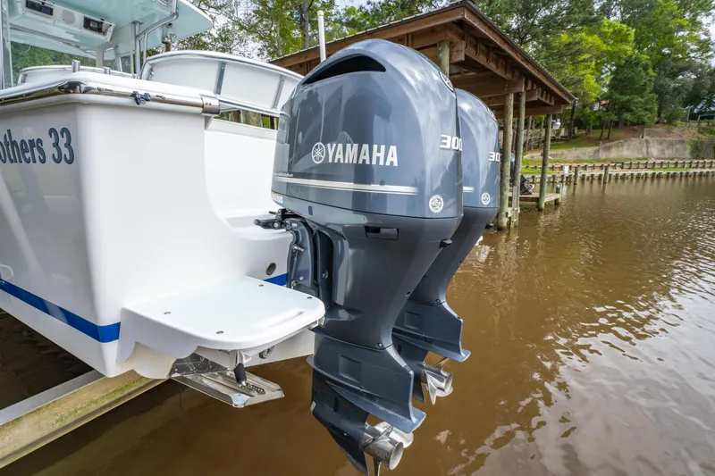 Slide: The Image of Albury Brothers 33 boat with dual Yamaha 300 engines, docked by a wooden pier. - 5