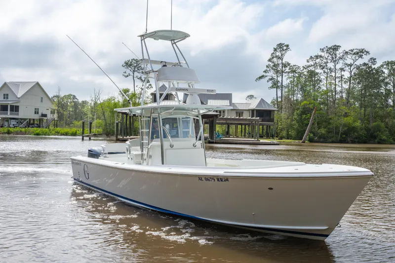Slide: The Image of 2018 Albury Brothers 33 boat on a calm river with houses and trees in the background. - 6
