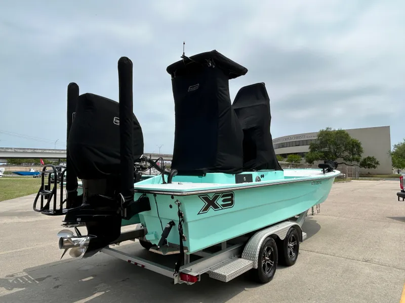 Slide: The Image of 2022 Shallow Sport 25 X3 boat on trailer, mint green hull, covered engines. - 18