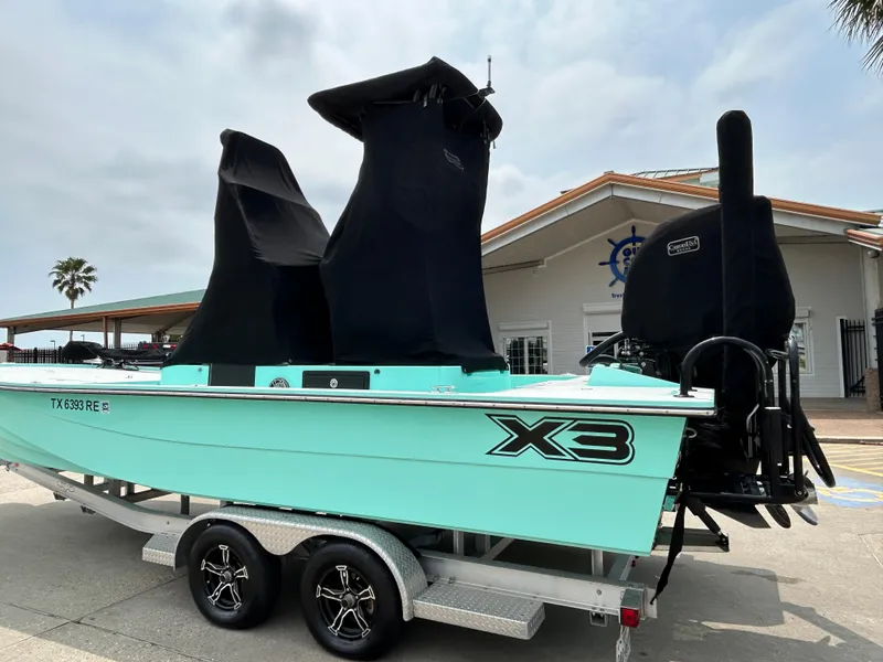 Slide: The Image of 2022 Shallow Sport 25 X3 boat on trailer, covered, parked near building. - 20