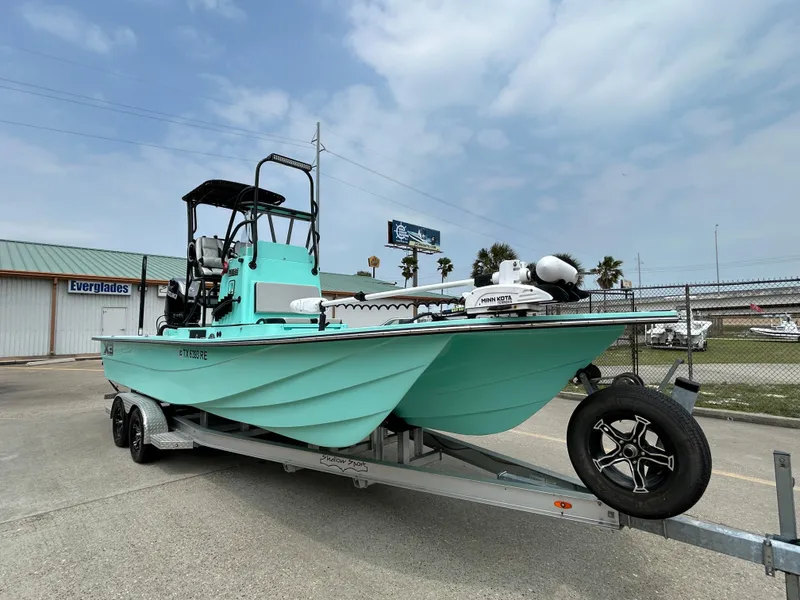 Slide: The Image of 2022 Shallow Sport 25 X3 boat on trailer, turquoise color, parked outdoors. - 3