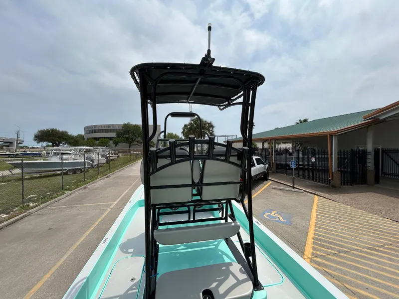 Slide: The Image of 2022 Shallow Sport 25 X3 boat with elevated seating, parked near a marina. - 8