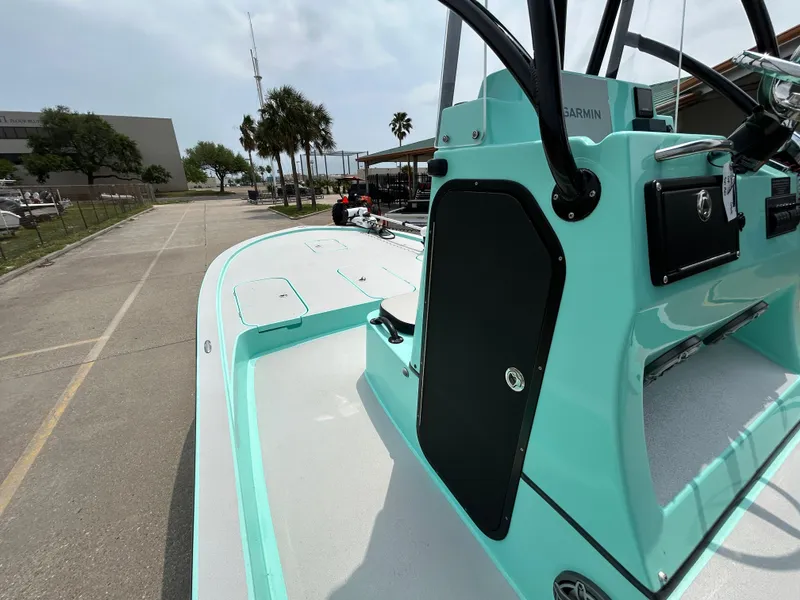Slide: The Image of 2022 Shallow Sport 25 X3 boat with mint green detailing, parked on a sunny street. - 9