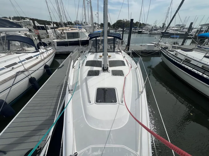 Slide: The Image of 2002 Hunter 386 sailboat docked at marina, surrounded by other boats. - 12